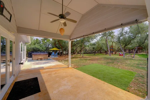a view of a patio with table and chairs under an umbrella