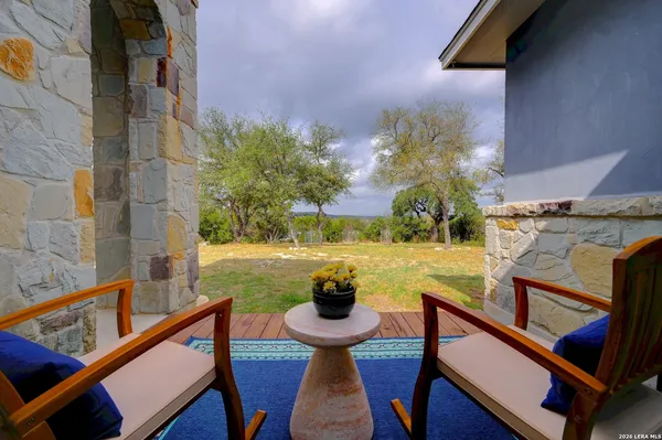 a view of a balcony with chairs and a potted plant