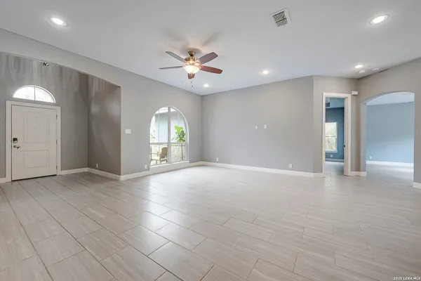 an empty room with fan and entrance door