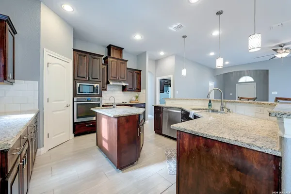 a large kitchen with kitchen island a sink stainless steel appliances and a counter top space
