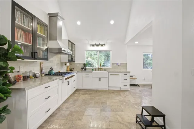 a large white kitchen with a large window