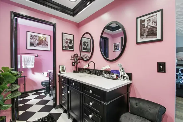 a bathroom with a sink a mirror and a wall painting