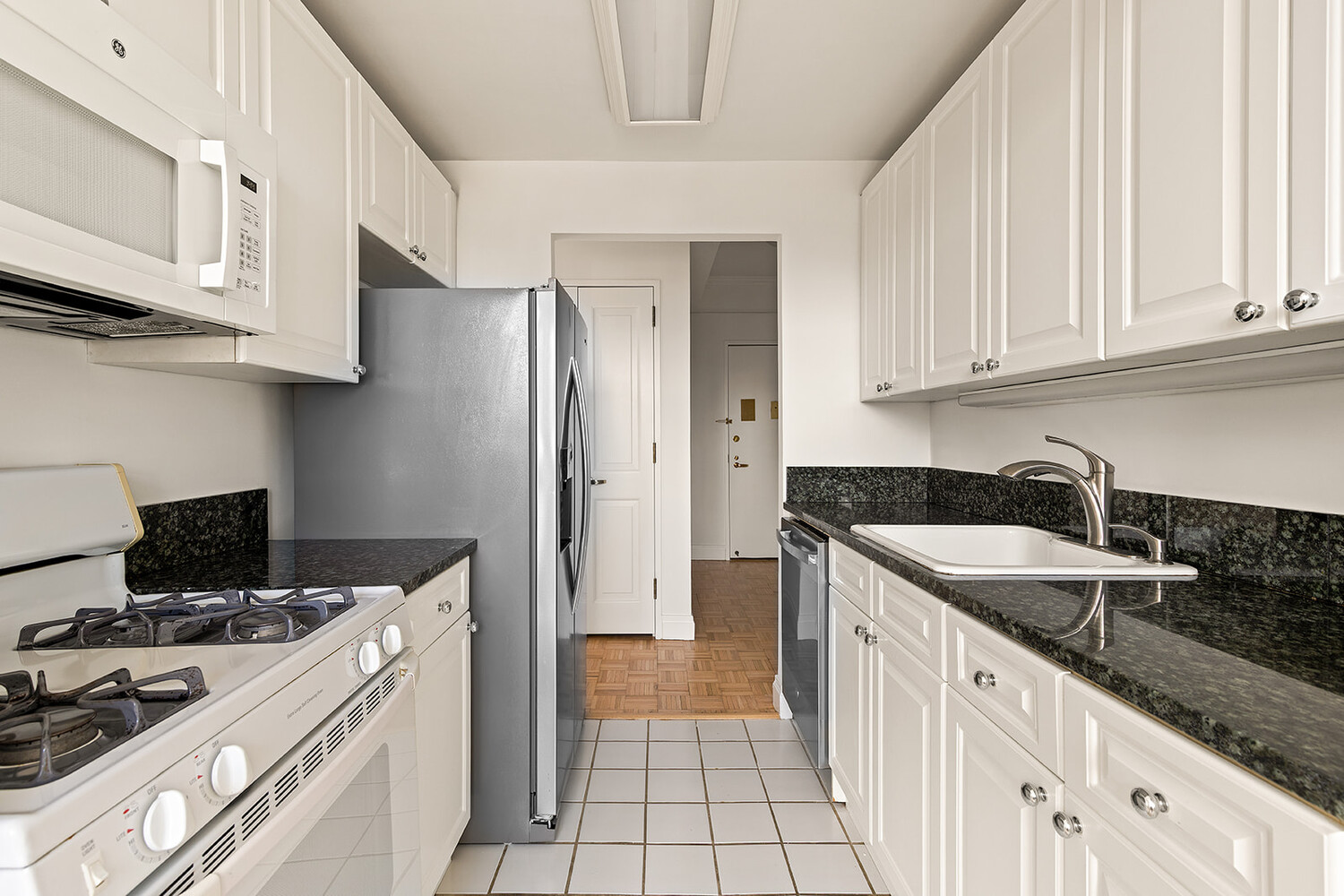 404 East 76th Street, Unit 10D Manhattan, NY 10021 - Photo 4 of 9 a kitchen with a sink stove and refrigerator