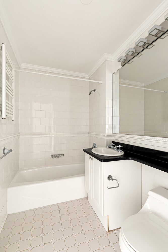 404 East 76th Street, Unit 10D Manhattan, NY 10021 - Photo 6 of 9 a bathroom with a granite countertop sink a toilet and bathtub