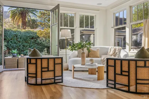 a view of a balcony with chairs and a potted plant