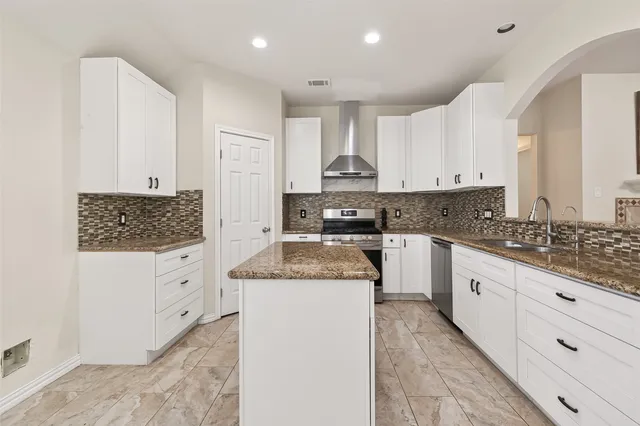 a kitchen with granite countertop white cabinets and white appliances