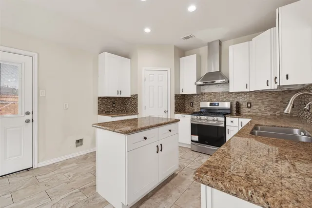 a kitchen with stainless steel appliances granite countertop a stove a sink and a refrigerator