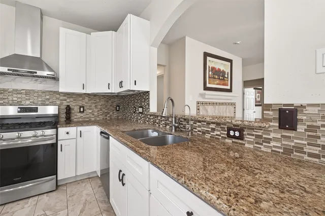 a kitchen with granite countertop a sink stove and cabinets