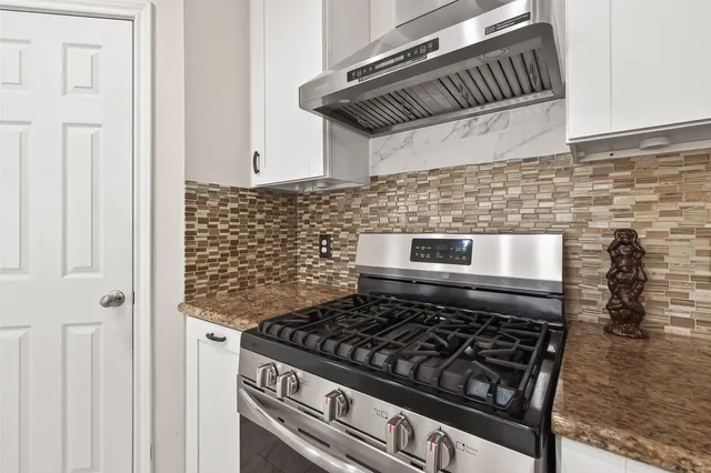 a stove top oven sitting inside of a kitchen