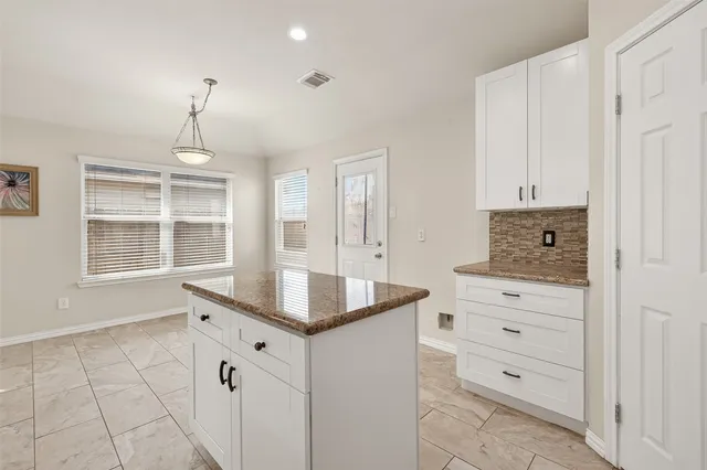 a kitchen with cabinets appliances a sink and a window