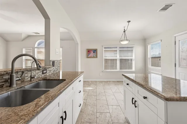 a kitchen with granite countertop a sink and a window