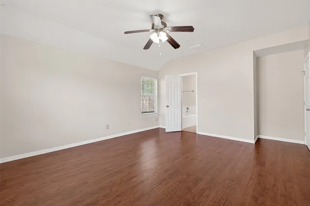 a view of room with hardwood floor ceiling fan and window