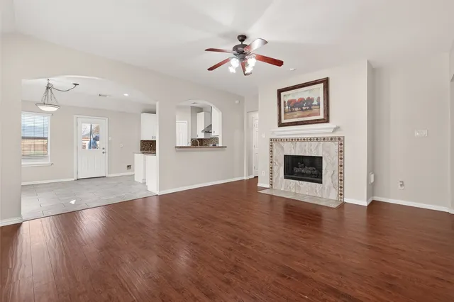 a view of a livingroom with wooden floor and a ceiling fan