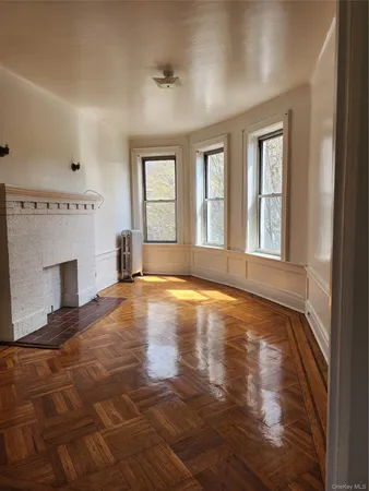 a view of an empty room with window and fire place