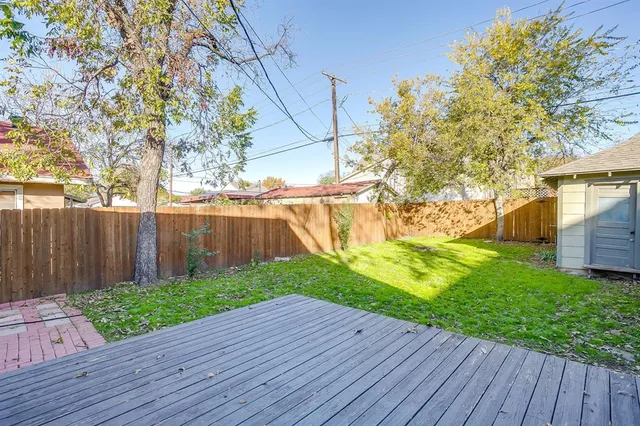 a view of backyard with wooden fence