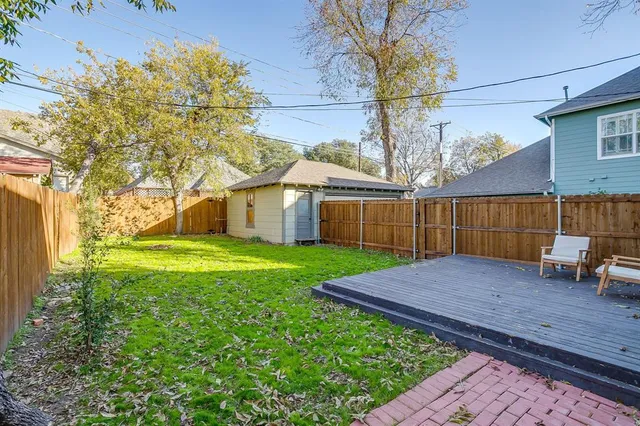 a view of backyard with table and chairs and wooden fence