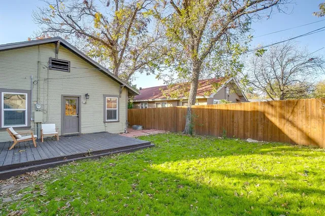 a view of backyard with table and chairs and wooden fence