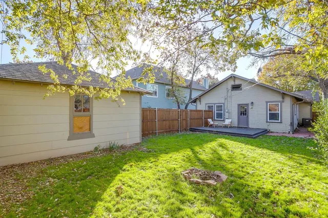 a backyard of a house with oven and wooden fence