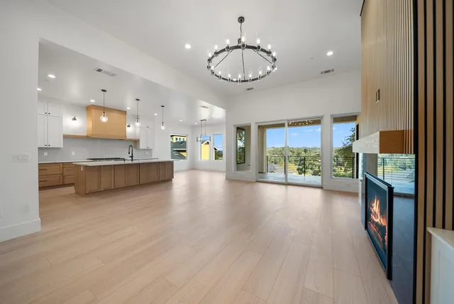 a view of a room with kitchen island stainless steel appliances large window and wooden floor