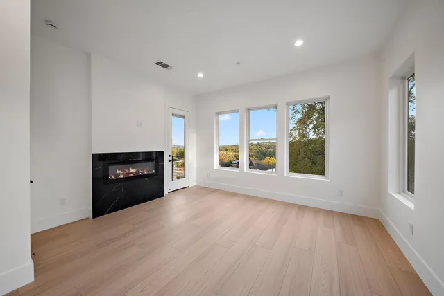 wooden floor fireplace and windows in an empty room