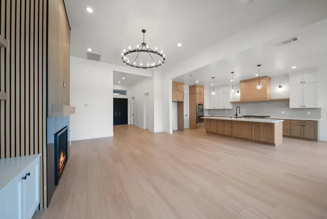 an open kitchen with a refrigerator and a stove top oven