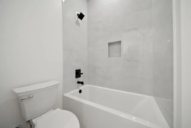 a white bath tub sitting next to a white toilet
