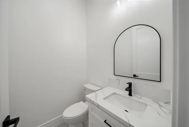 a bathroom with a sink a toilet and a mirror