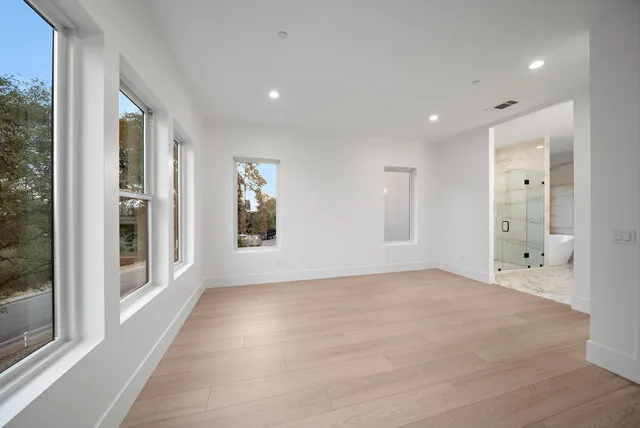 a view of an empty room with glass door and a window