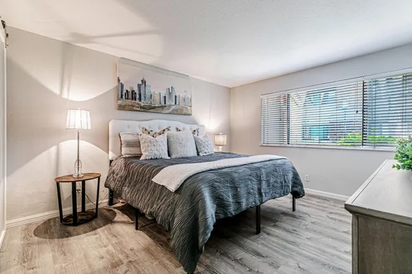 a bedroom with a bed a mirror and a large window