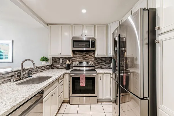 a kitchen with stainless steel appliances granite countertop a stove a sink and a refrigerator