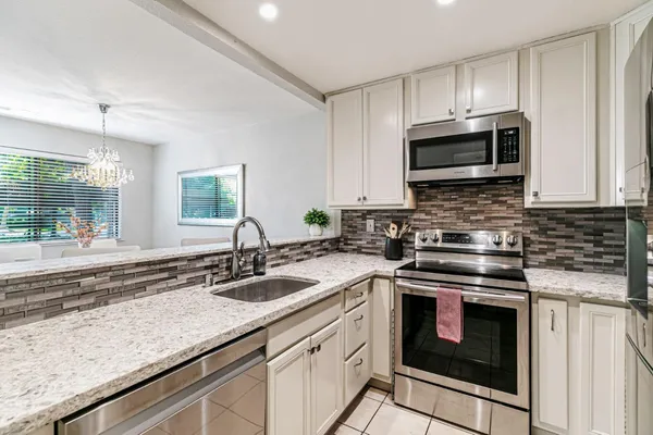 a kitchen with stainless steel appliances granite countertop a sink stove and microwave