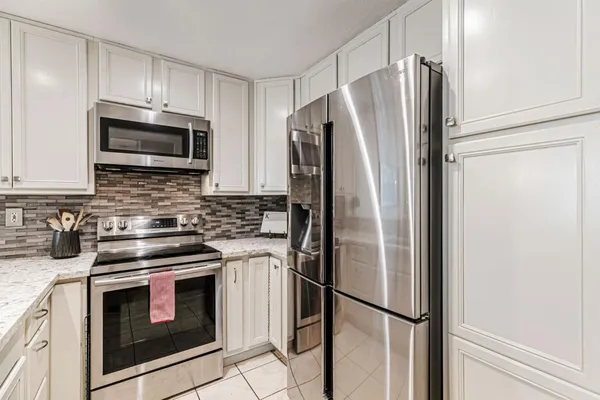 a kitchen with stainless steel appliances a refrigerator sink and microwave