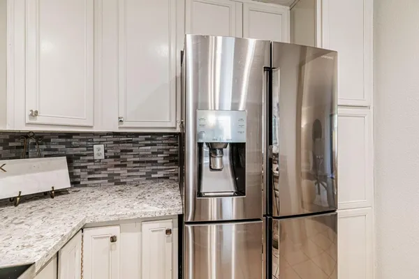 a kitchen with stainless steel appliances granite countertop a refrigerator and a sink