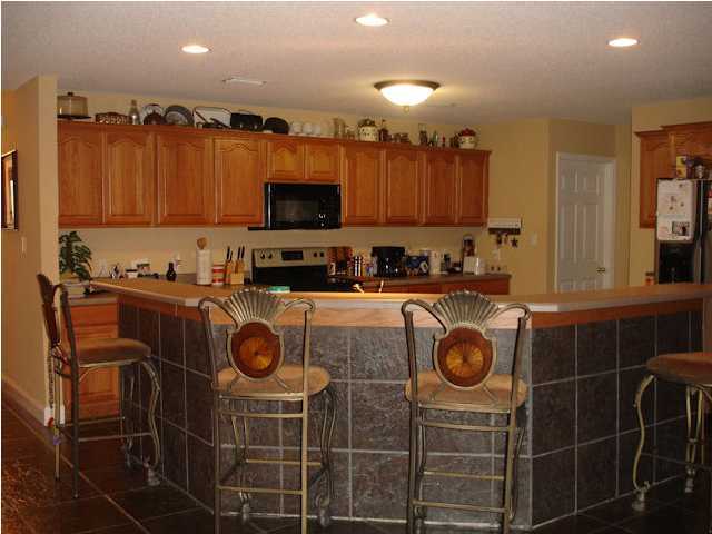 5127 Keyser Mill Road Baker, FL 32531 - Photo 7 of 13 a kitchen with kitchen island granite countertop a sink a stove a microwave and cabinets