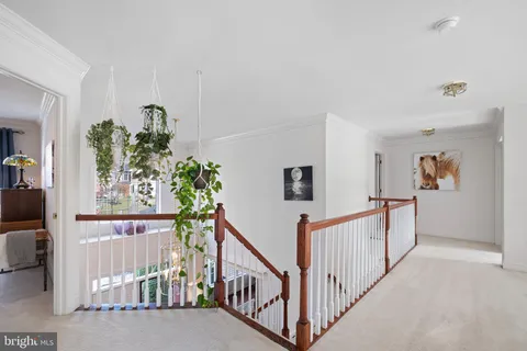 a view of a hallway with wooden floor and stairs