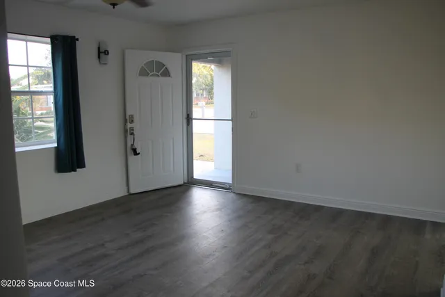 a view of a room with wooden floor and a window