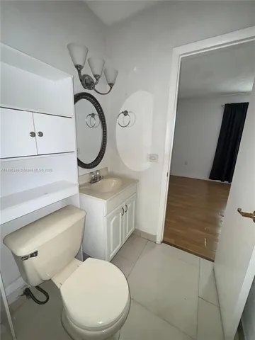 a bathroom with a granite countertop toilet sink and mirror
