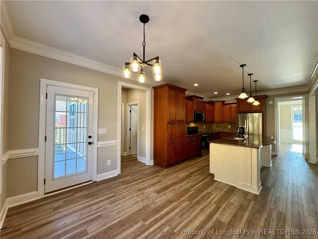 a view of a kitchen with refrigerator and wooden floor