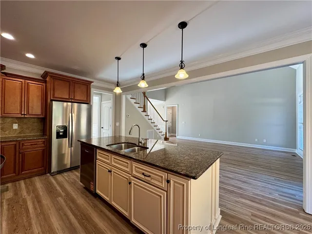 a kitchen with stainless steel appliances granite countertop a sink a stove and refrigerator