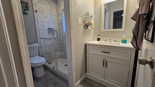 a bathroom with a granite countertop sink toilet and shower