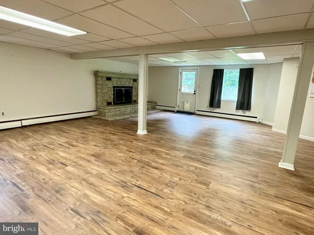 a view of an empty room with wooden floor and closet