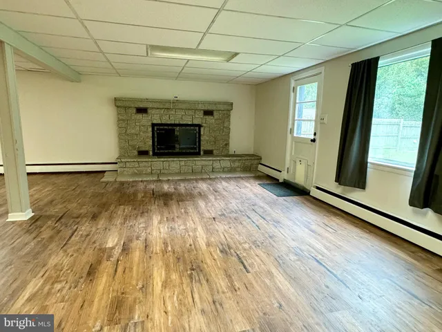 a view of empty room with wooden floor and fireplace
