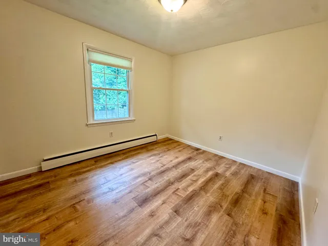 a view of a room with wooden floor and a window