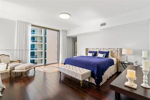 a bedroom with a bed a couch and a window with outer view