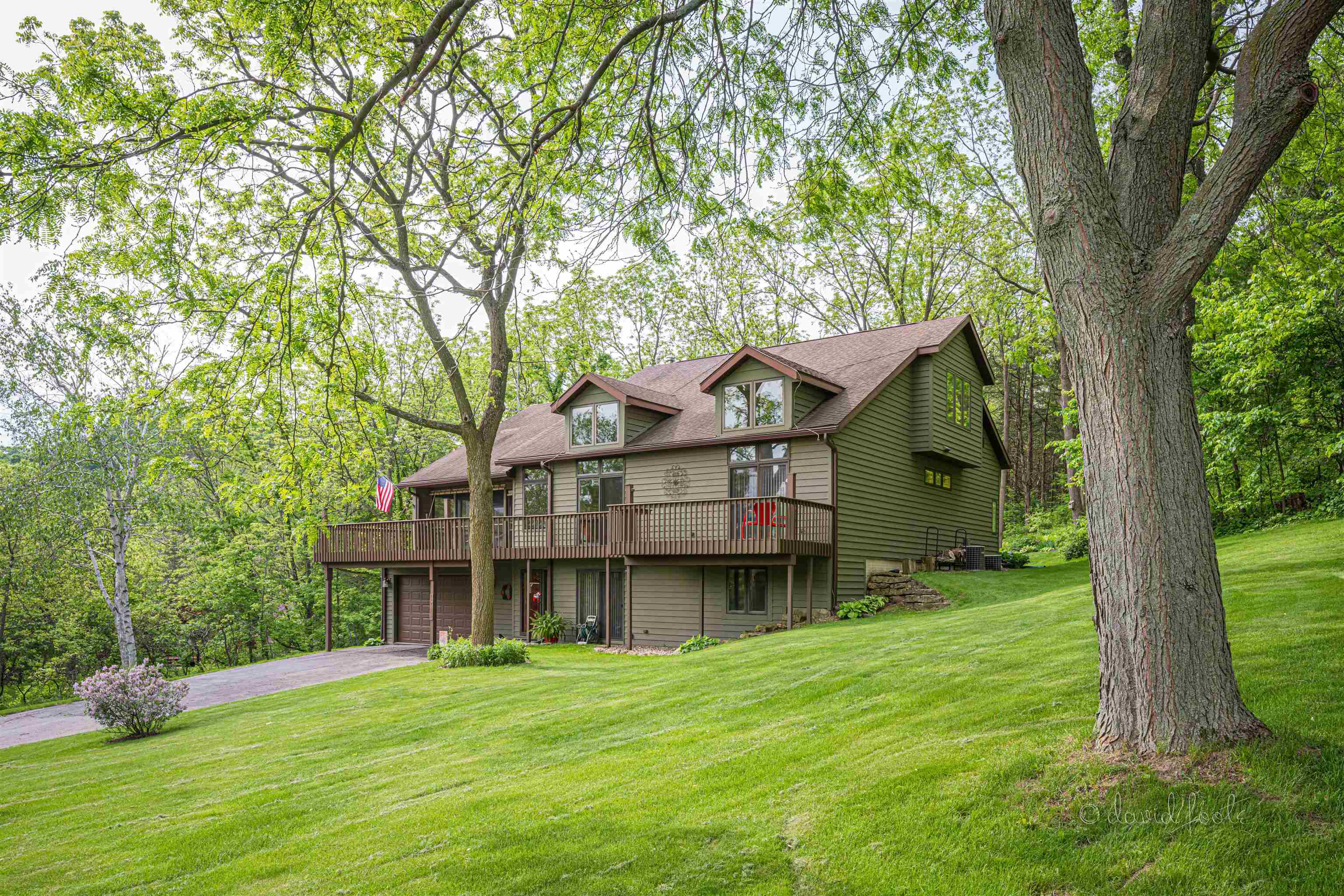 a front view of a house with a garden and trees