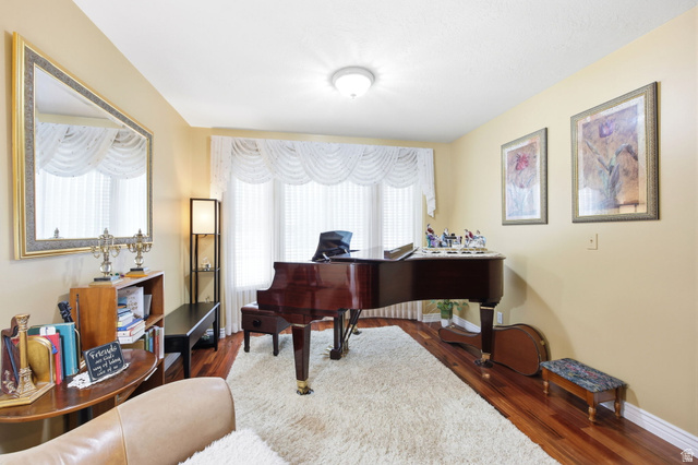 776 Flint Street Layton, UT 84041 - Photo 19 of 41 Living space featuring wood-finish flooring, a large bay window with white valances, and light-toned wall paint