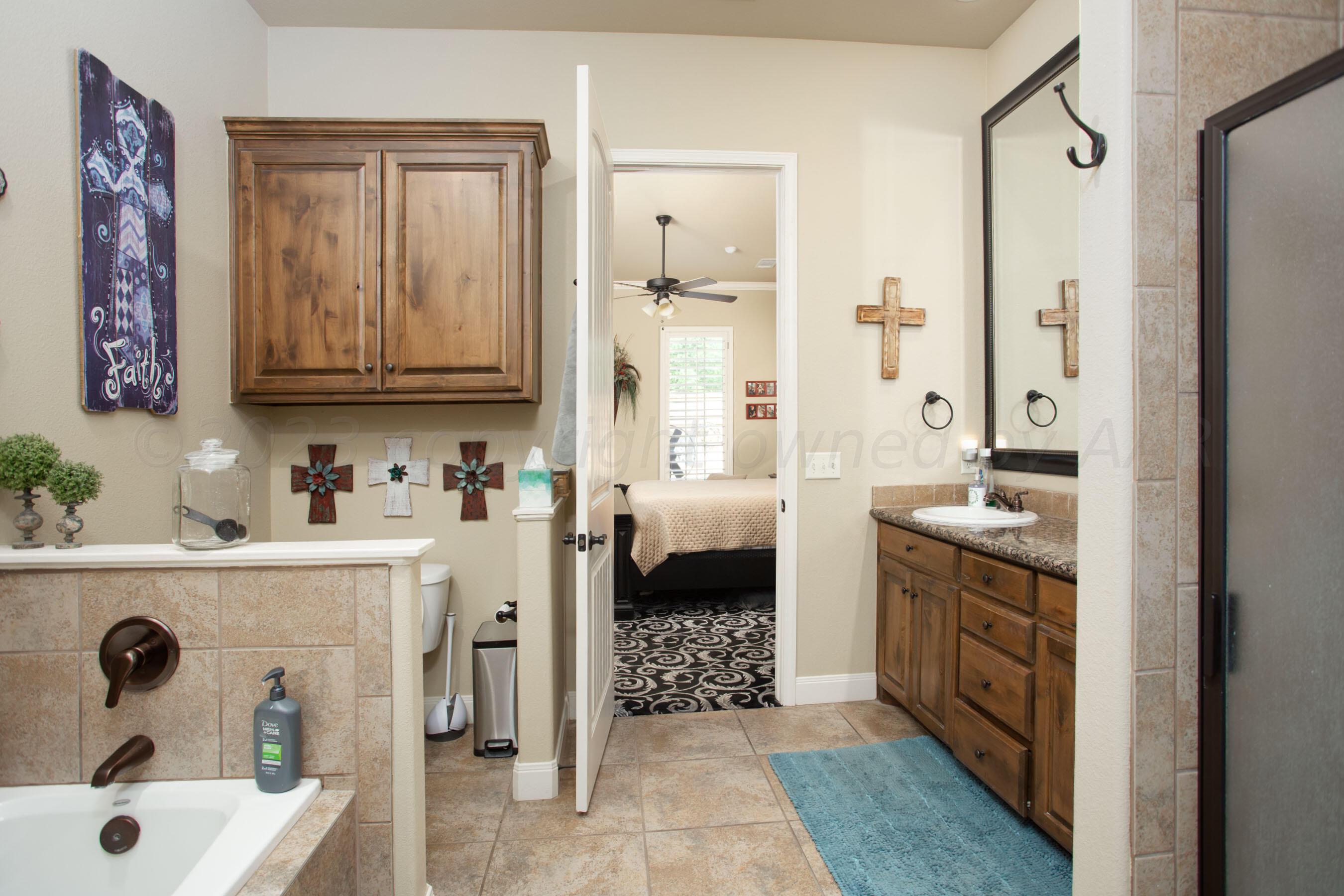 7105 Nick Street Amarillo, TX 79119 - Photo 15 of 24 a bathroom with a tub sink and mirror