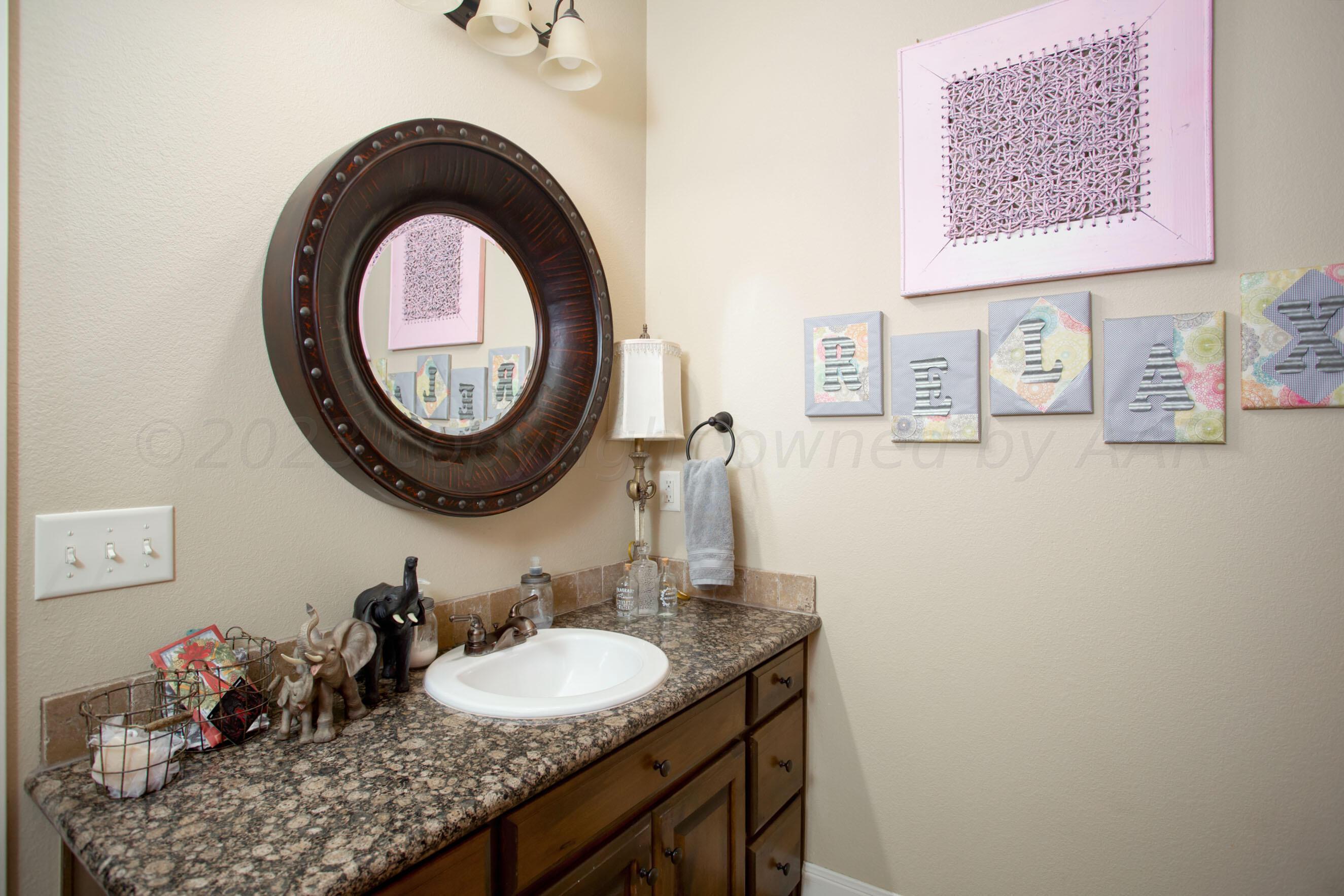 7105 Nick Street Amarillo, TX 79119 - Photo 18 of 24 a bathroom with a sink and a mirror
