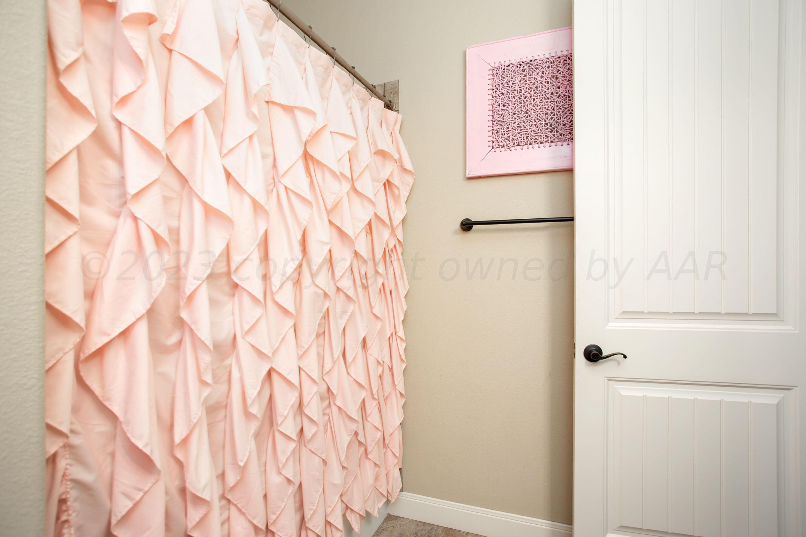 7105 Nick Street Amarillo, TX 79119 - Photo 19 of 24 a bathroom with a shower curtain and a sink