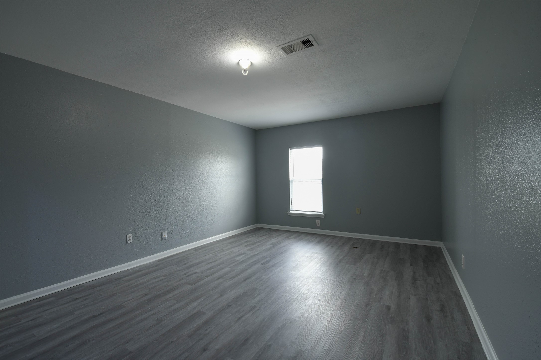 727 Dell Dale Street Channelview, TX 77530 - Photo 7 of 14 an empty room with wooden floor and windows